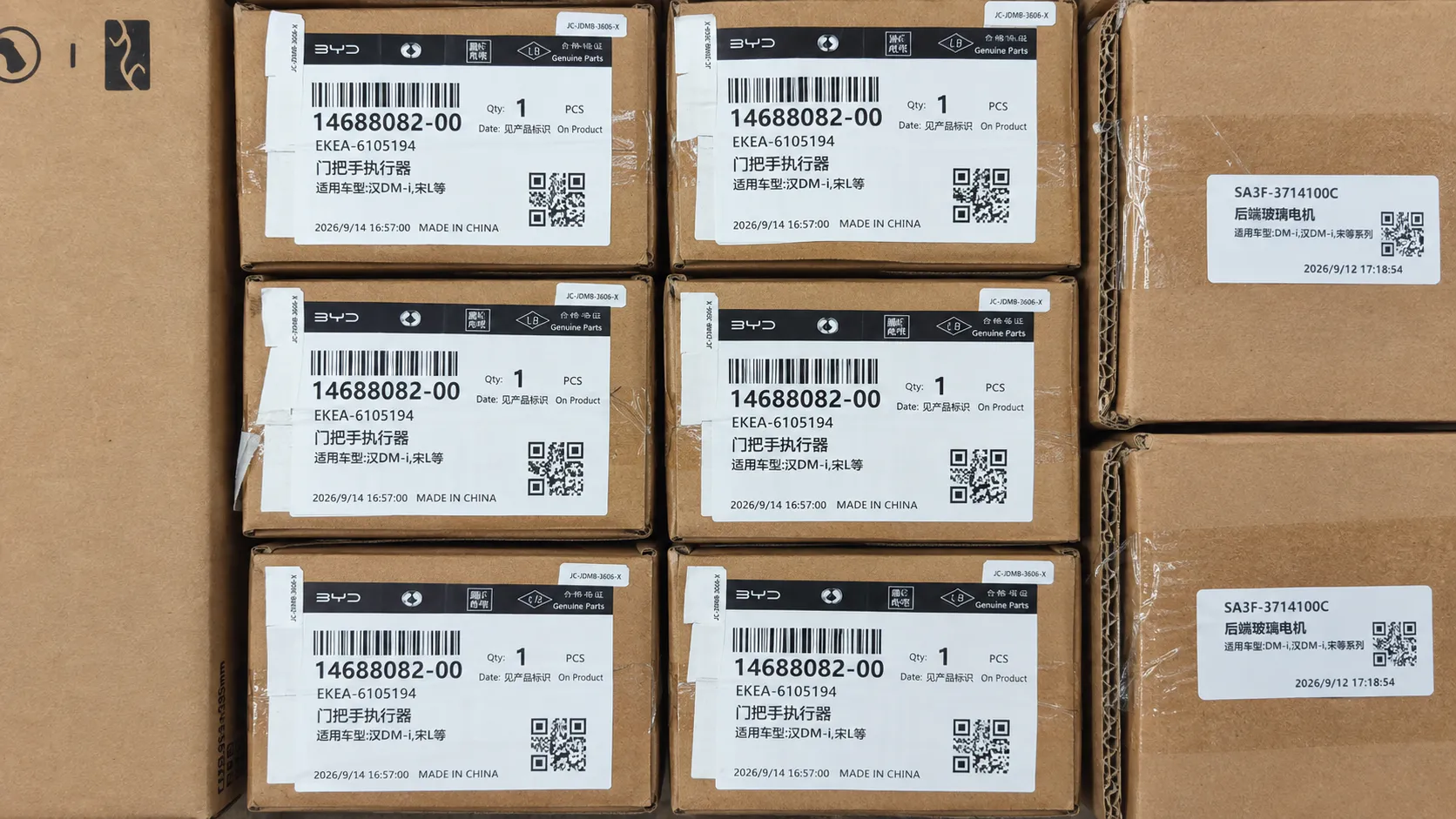 Labeled automotive parts cartons arranged for part-code and quantity checking